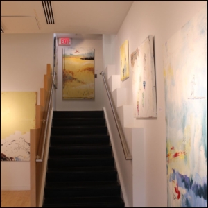 The gallery exhibit space stairs with McDonnell's paintings going all the up and at the landing of the next floor.