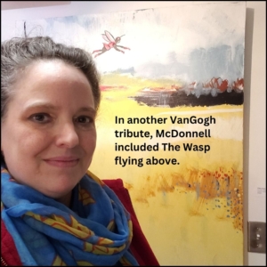 Amber in front of on of McDonnell's paintings done as tribute / homage to Vincent VanGogh with a yellow field and above is Marvel Comics character The Wasp flying.